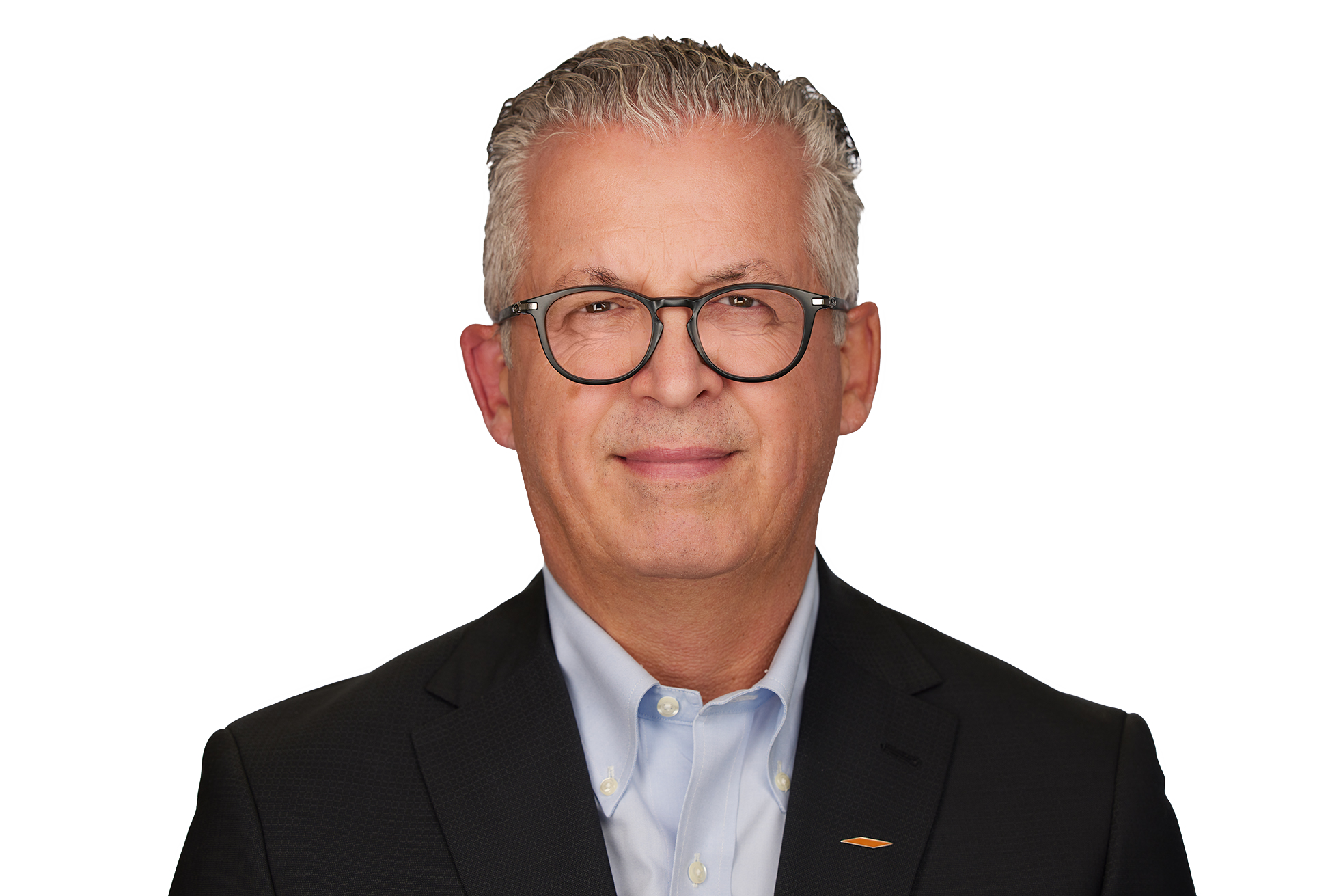 Teri McKibbon new Head Shot A middle-aged man with gray hair wearing glasses, a dark suit, and a light blue shirt, posing against a plain white background.